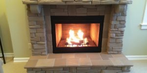 Modern fireplace remodel with stone surround and hearth.